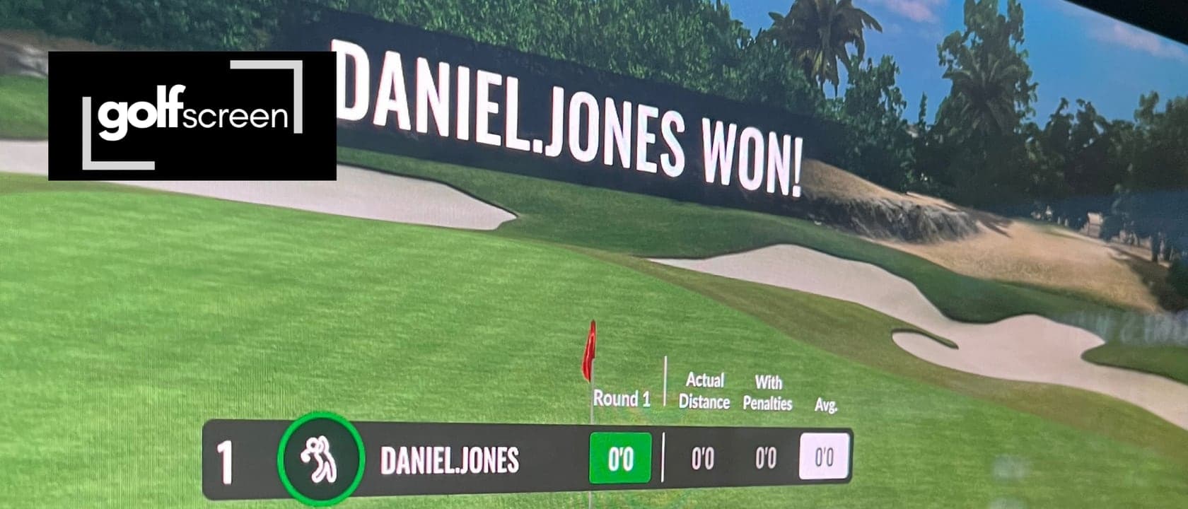 An impact screen under tension in a simulator bay, a golf hole projected across it with a game's closing scoreboard, and the darkened room visible at the screen's edge